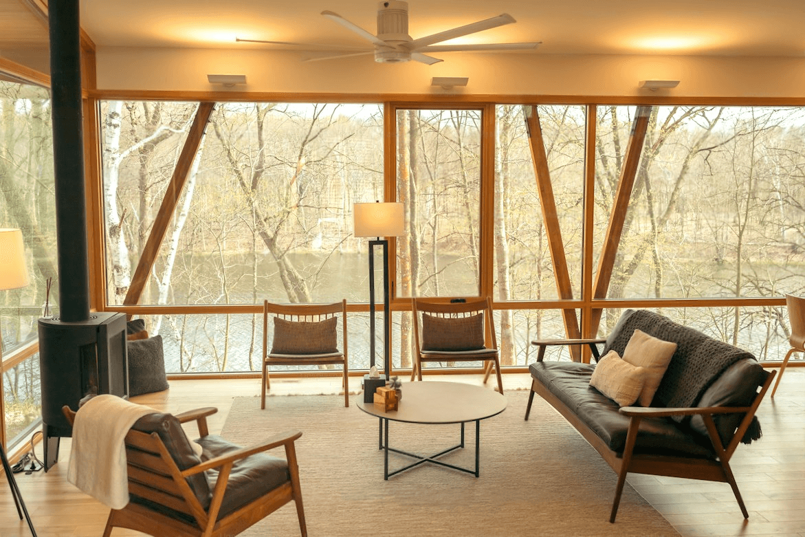 Sunlit living area with timber framing, lounge seating and floor-to-ceiling windows