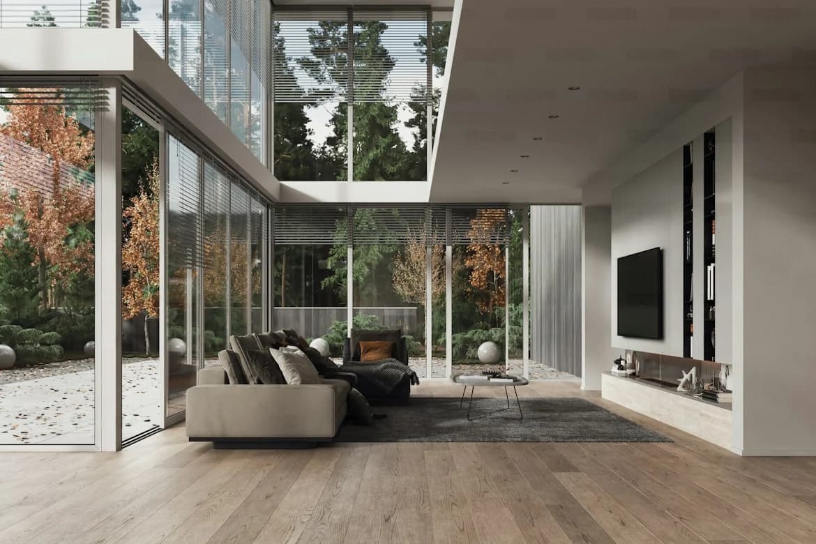 Double-height living room with garden-facing glass walls, low sofas, a dark rug and a pale media wall